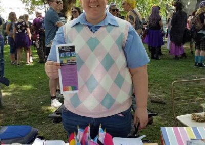 volunteer holding LGBTQ rights pamphlet at booth