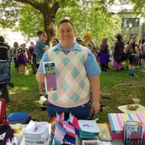 smiling person at event holding pamphlet